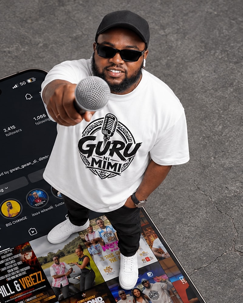 MC GURU wearing the Guru Ni Mimi tee, holding a microphone